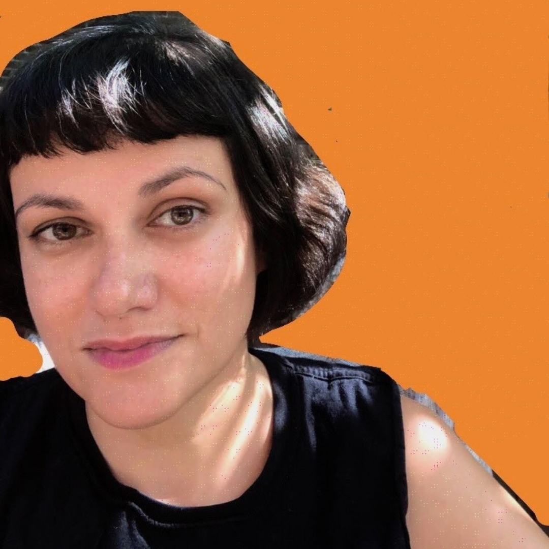 Zehra Khan — Artist Portrait Color portrait of artist Zehra Khan standing against a solid orange background. She has short dark hair with bangs and wears a sleeveless black top, looking directly at the camera with natural outdoor lighting creating soft highlights and shadows.
