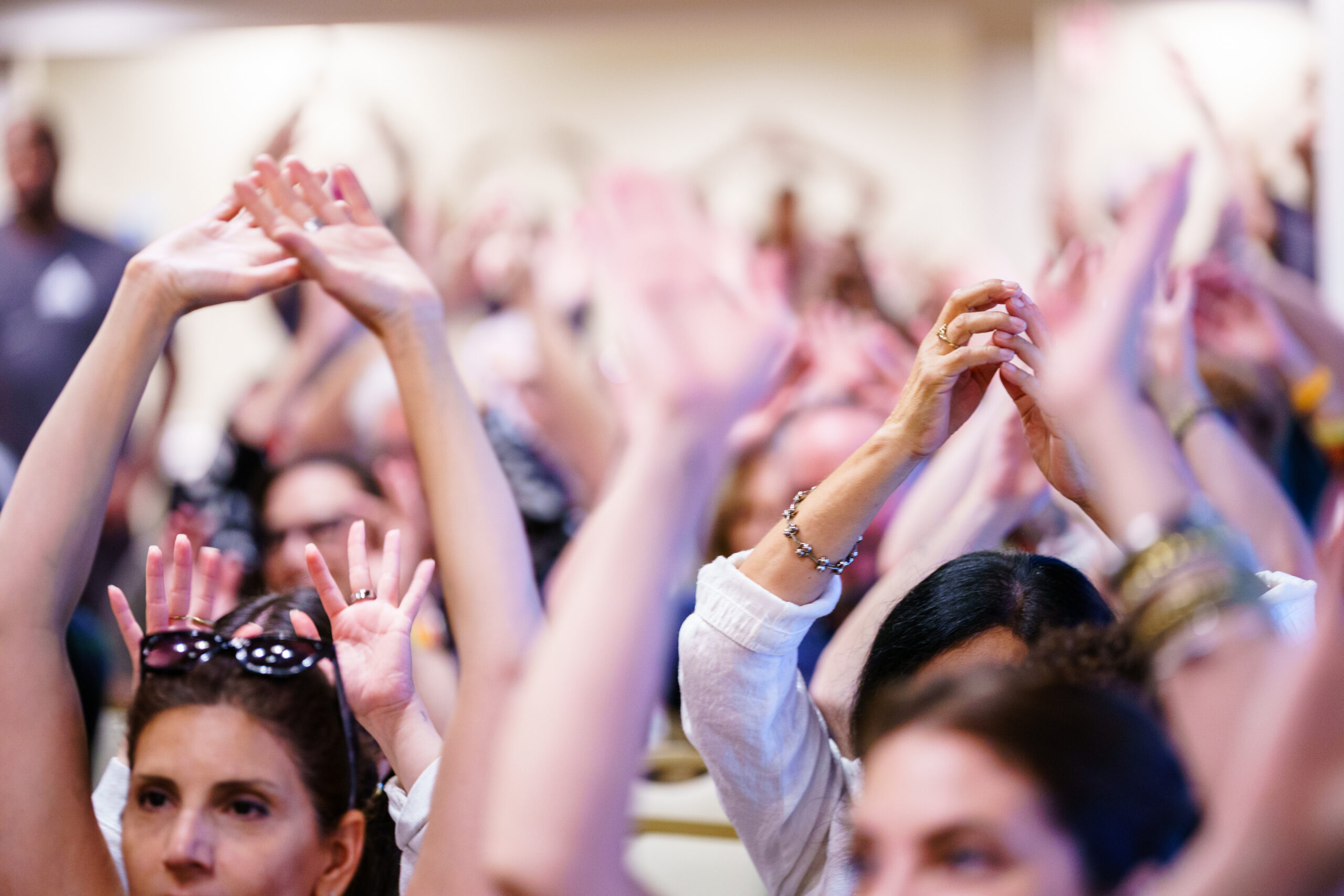 Participants at Day of Belonging 2026 at Rockwood Manor on September 19 raise their hands during a group activity; photo by Doug Sanford.